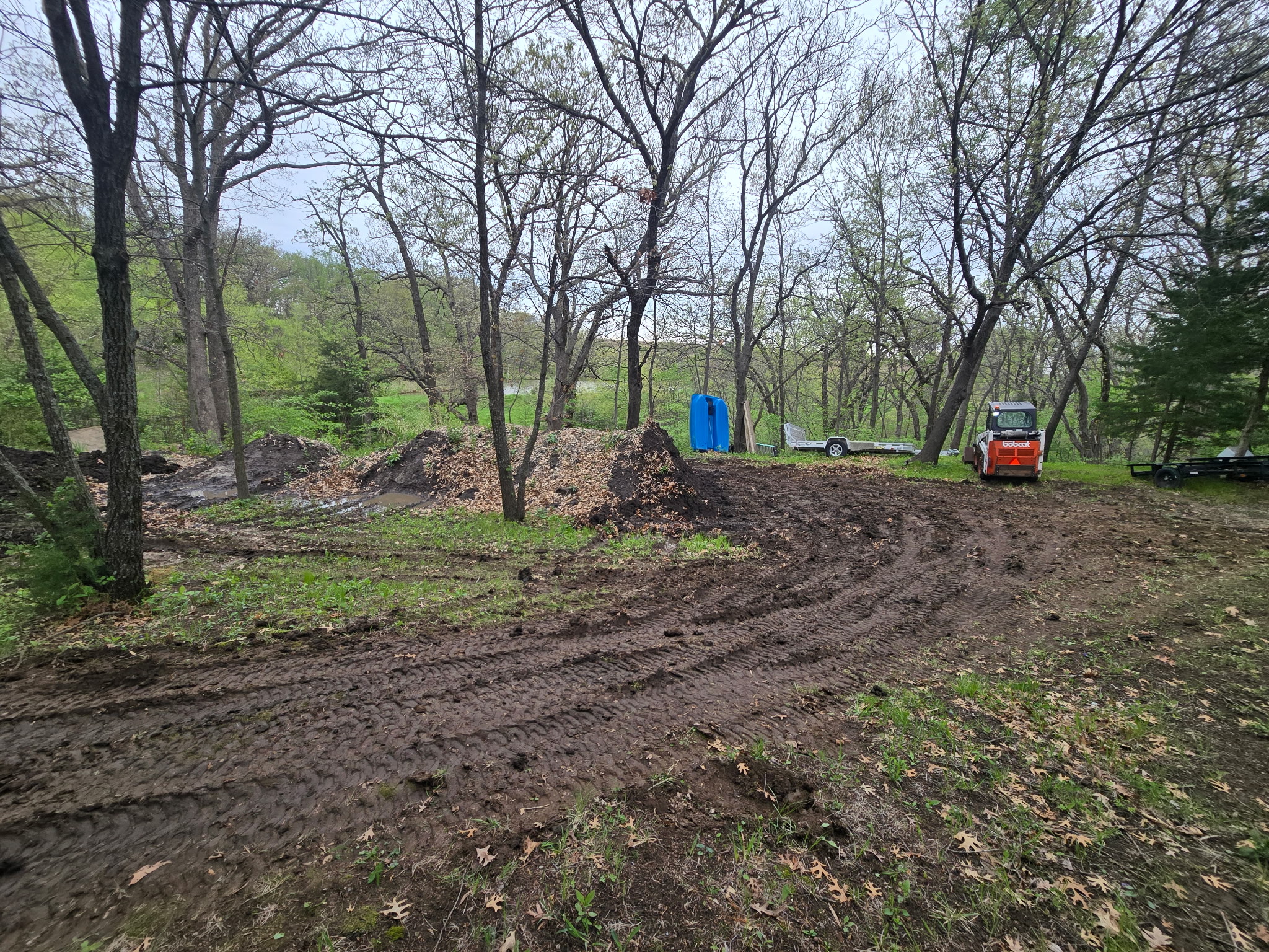 Skid-steer grading work in a wooded lot